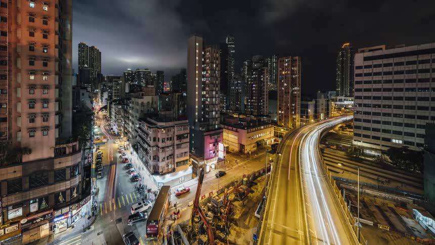 Traffic flows along streets and highway through downtown at night