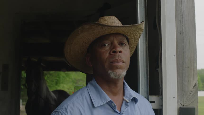 A man is standing near his horse