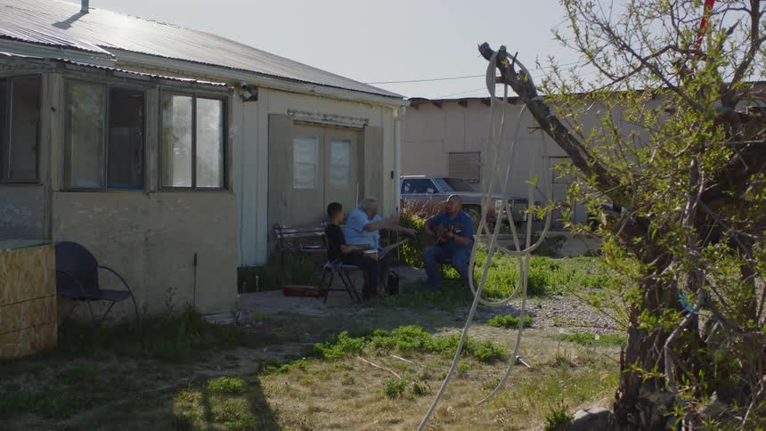 A family sit in the yard together