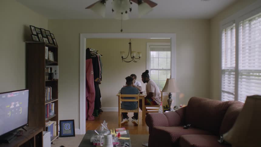 A family of three sits down for dinner together at home