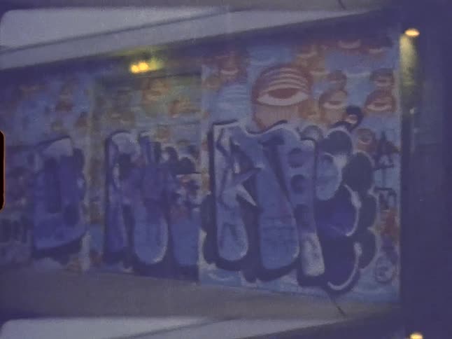 Graffiti covers the walls of a building with a garage door