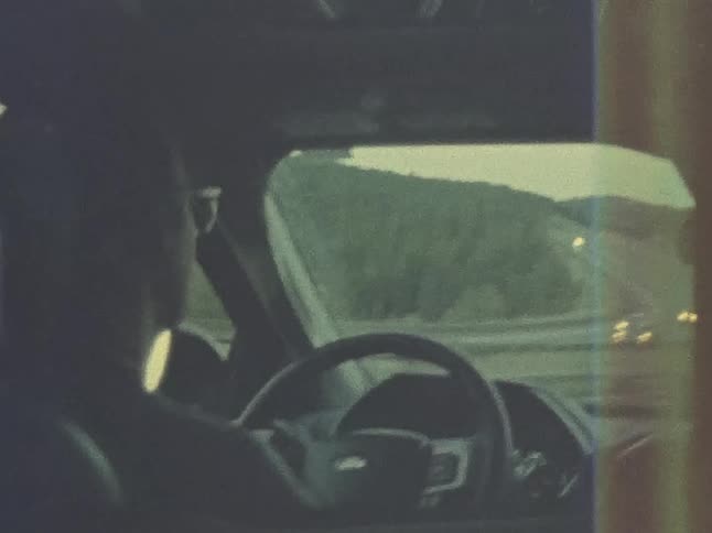 A man drives a vehicle along a highway during the day