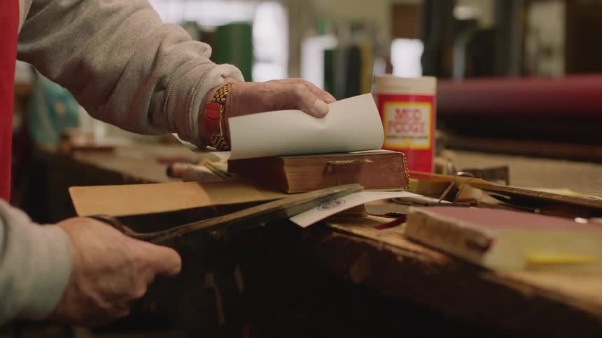 A man repairs books in his store