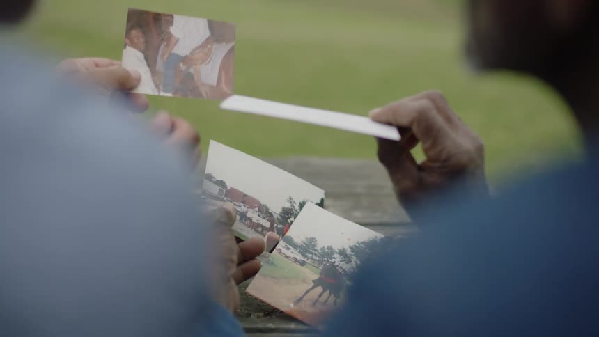 View over the shoulders of two people sitting together looking at photographs
