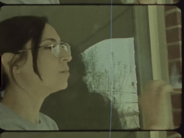 A woman inhales then passes a cannabis cigarette