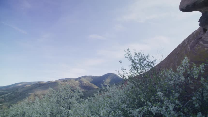 A rock formation sits above hills in a canyon