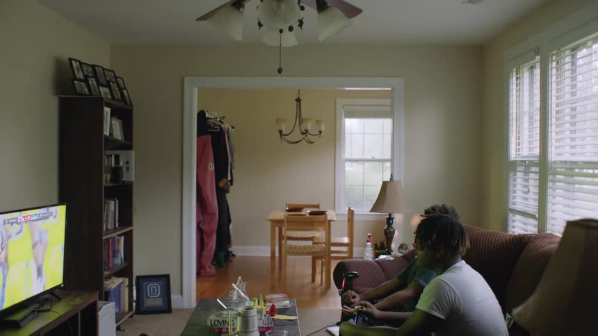 Brothers sitting on the living room couch playing video games