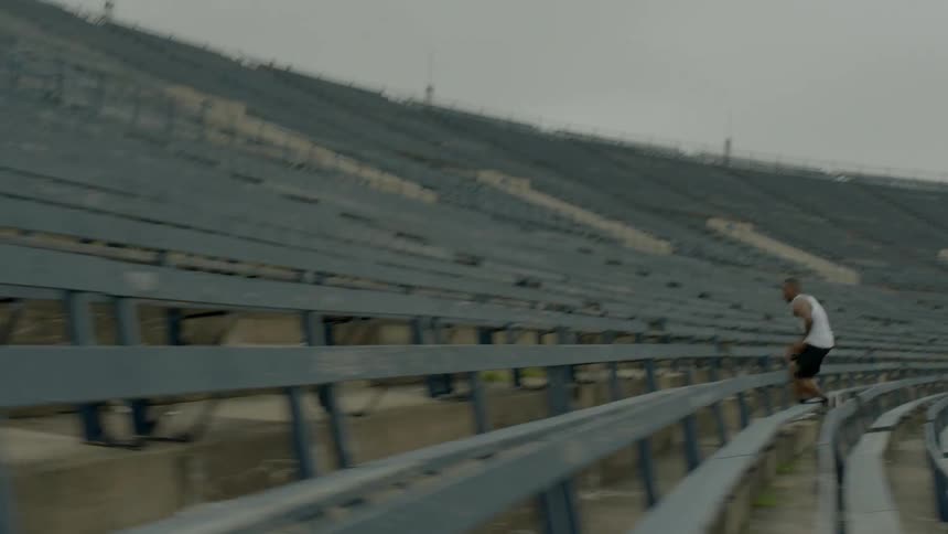 A man runs quickly up bleachers