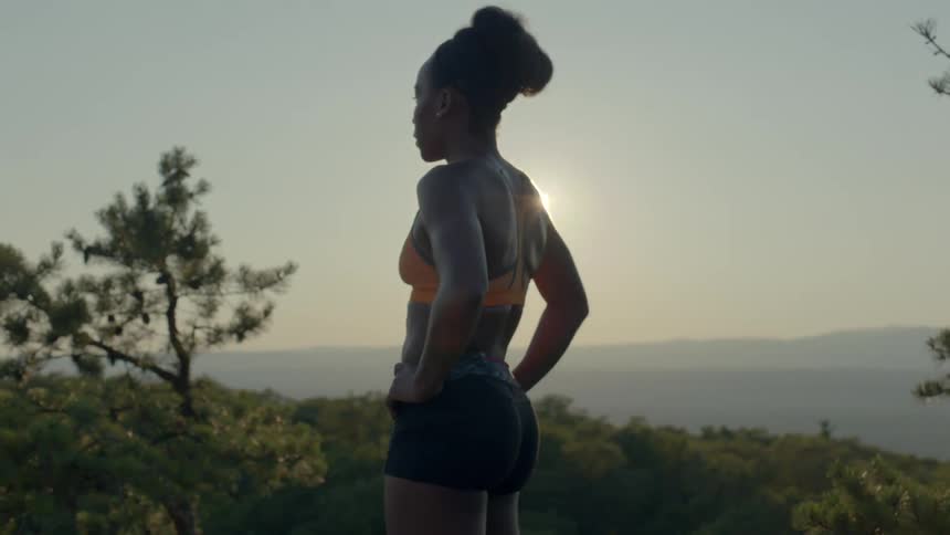 Woman standing in the grass at sunset