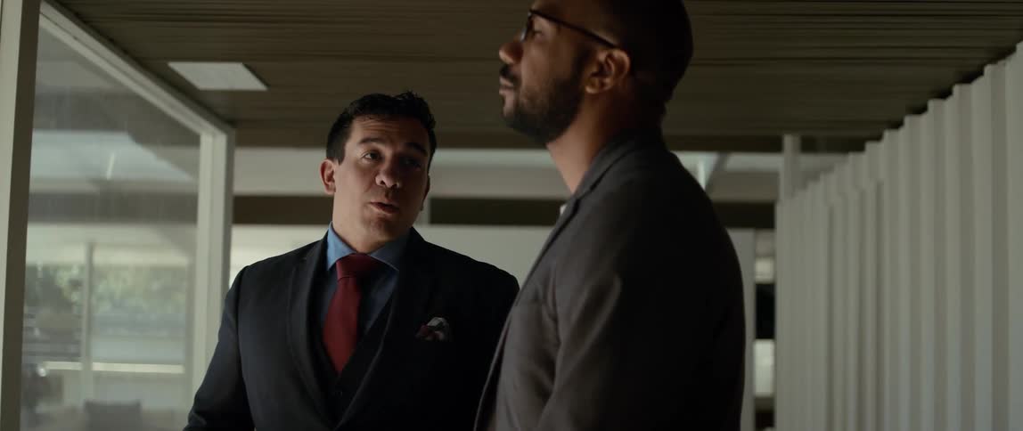 Two men are talking and one man nods his head as he listens to the other man speak