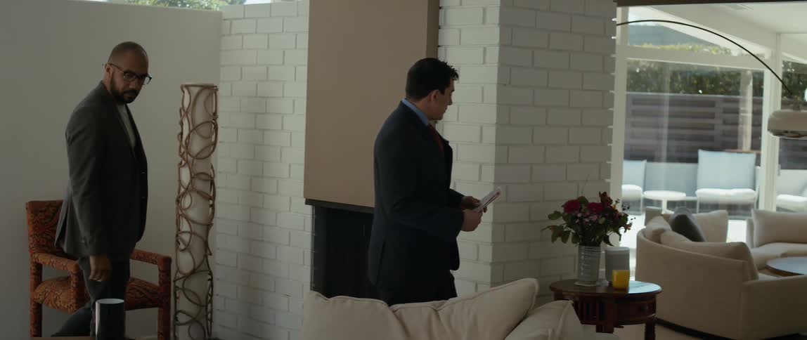 A realtor points and gestures as he shows a luxurious home to a client