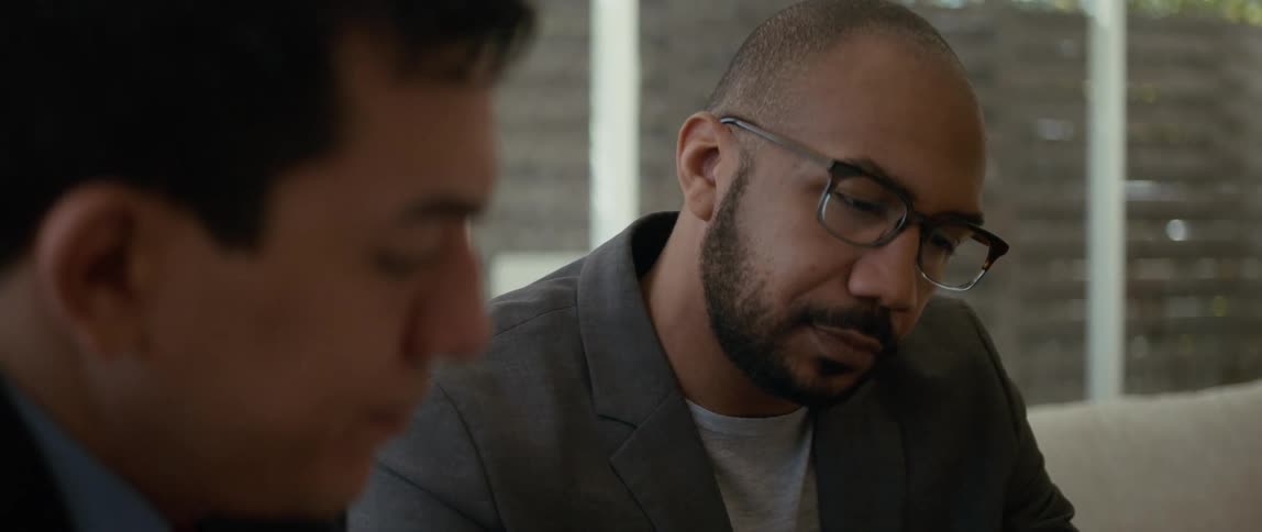 Two men in an office look down at something
