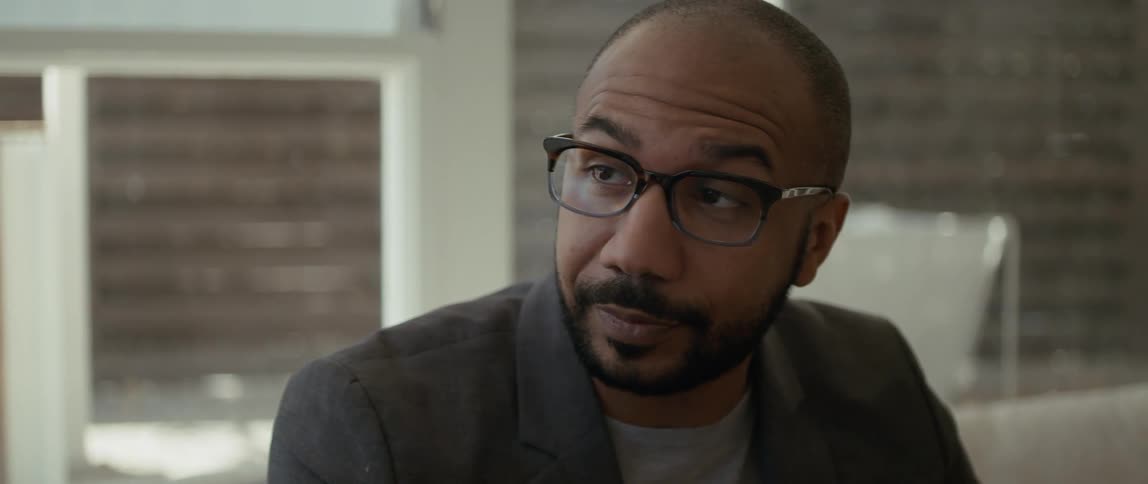 A man in an office nods his head and talks