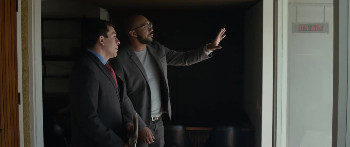 A man looking at office space with a realtor talks and gestures with his hand