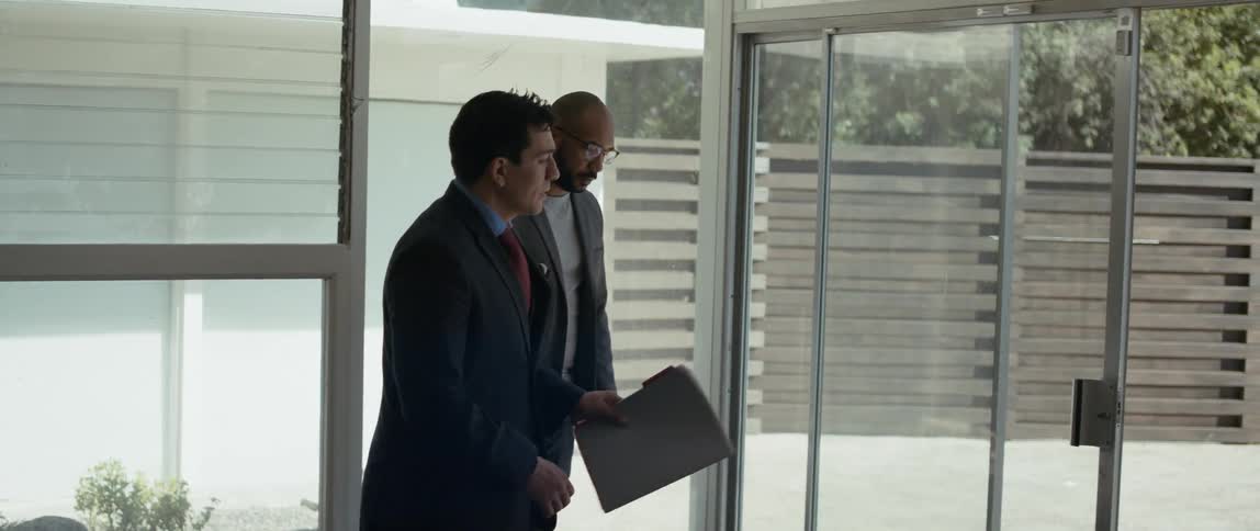 A real estate agent is talking to a man while showing a home