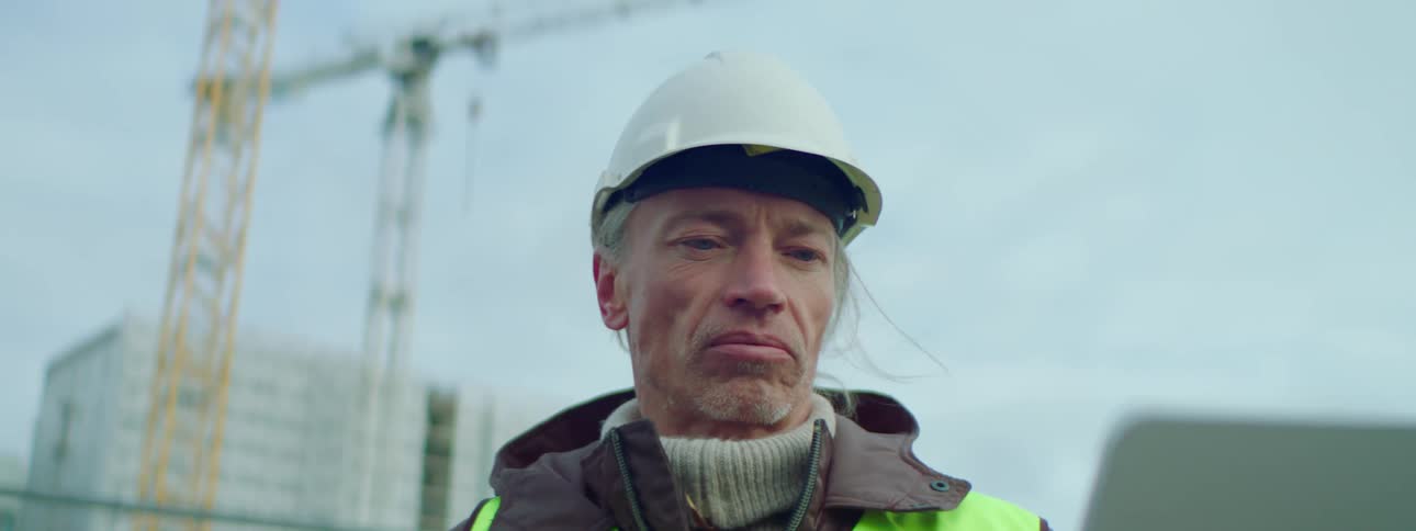 A construction worker talking out at a job site