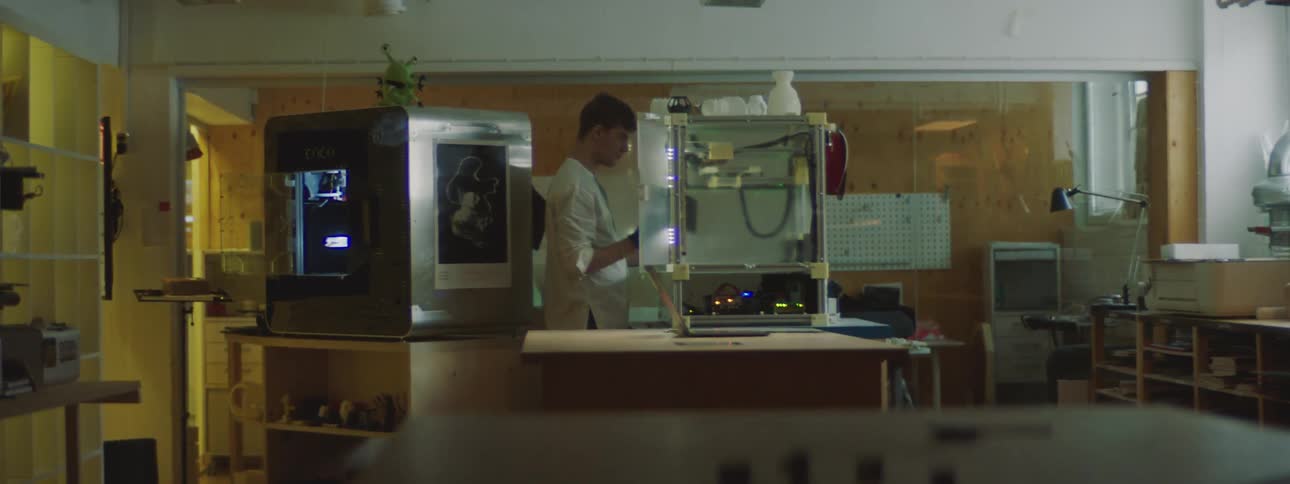 A man in a factory places a board in a machine