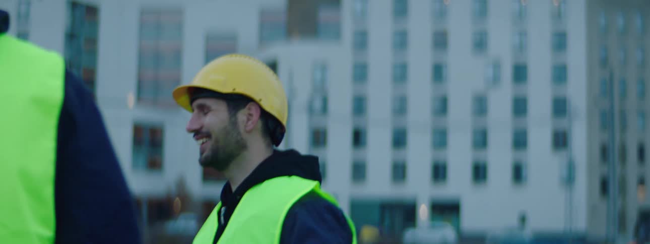 Two constructions workers laugh on the site