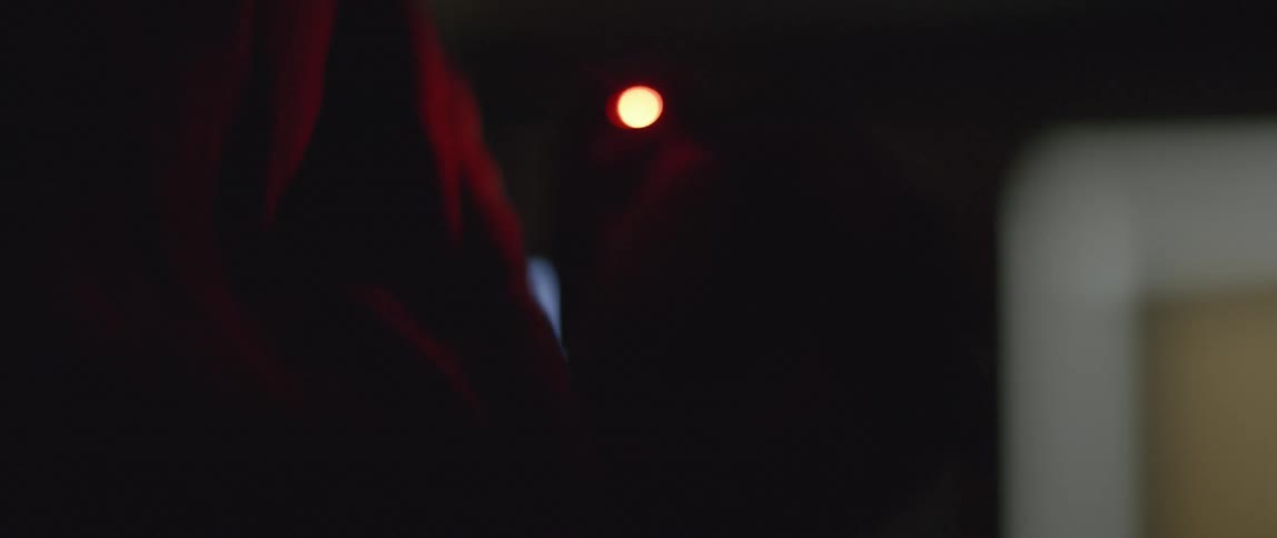 A person is holding a device with a flashing red light