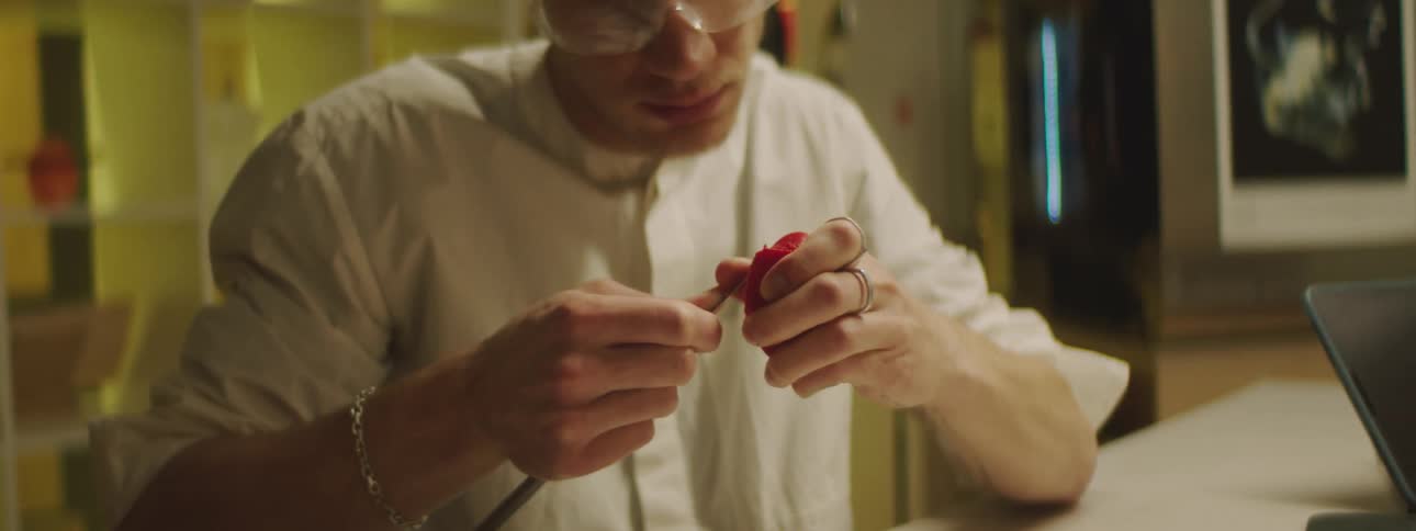 A man is carving a piece of plastic
