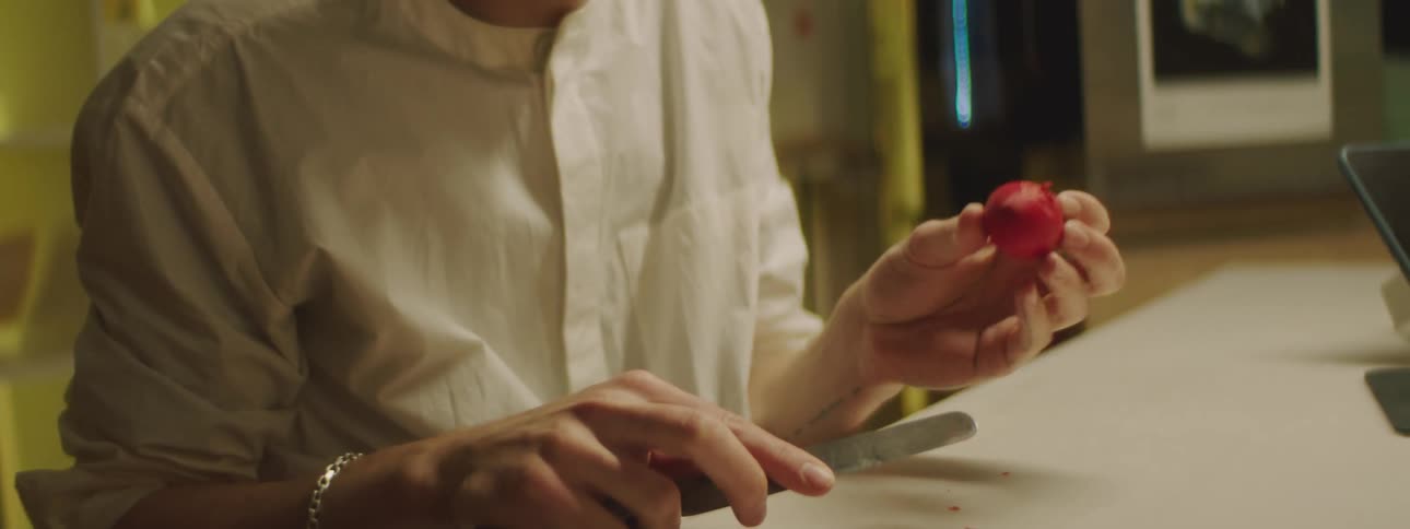 A man wearing safety goggles uses a knife to remove a knob from a plastic molded shape