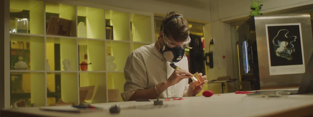 San wearing safety glasses and air filtration mask cutting smalls pieces of fruit with a knife on a beaker in a laboratory