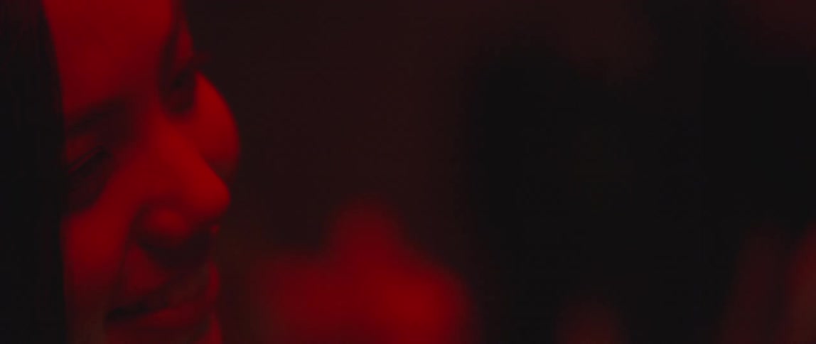 A woman talks and brushes her hair in a dark area