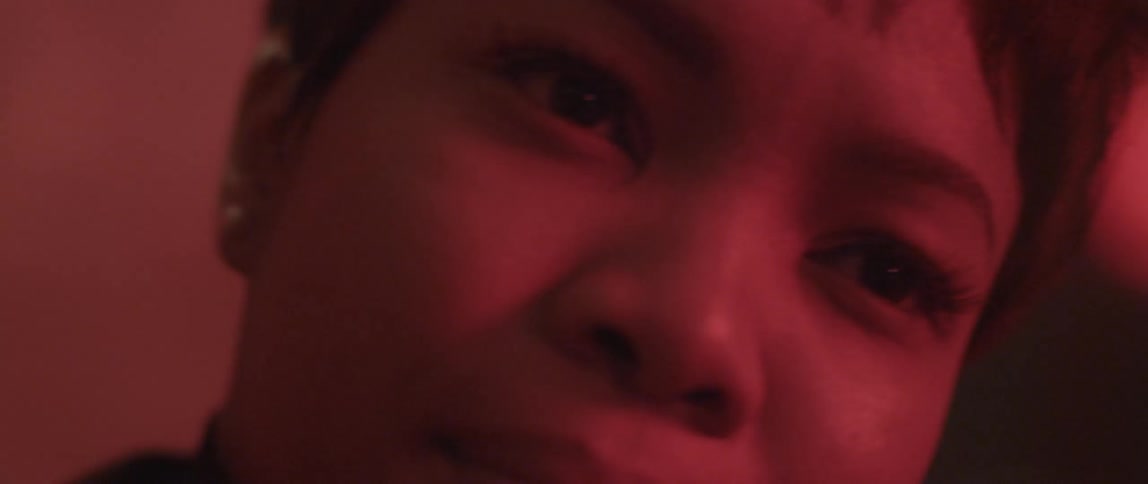 A woman is looking at something in a red hue area