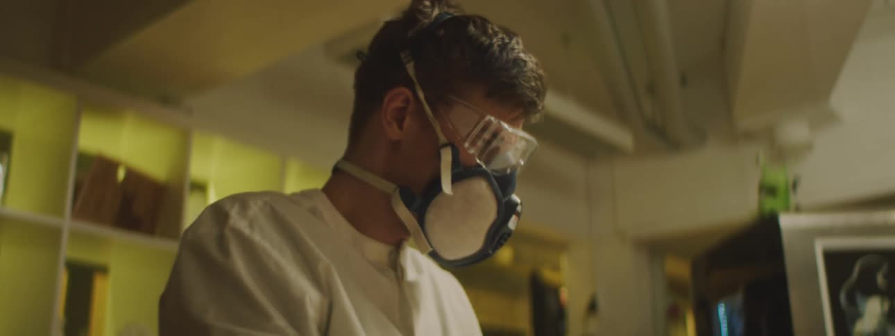 Man wears respirator and safety glasses while working