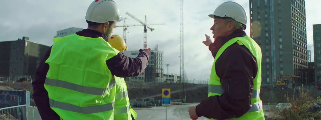 Construction workers stand at a job site and talking about something