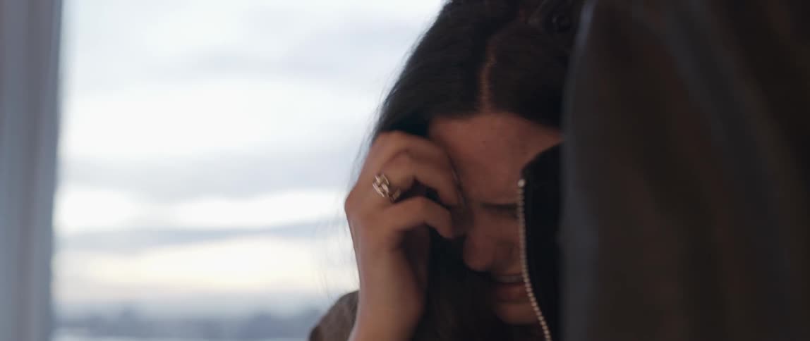 A woman with dark hair cries against another person