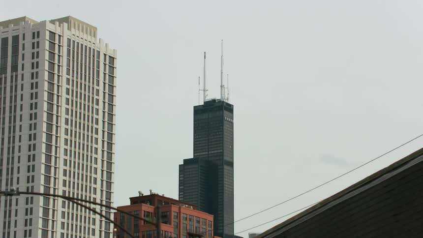 A skyscraper looms over a metropolis during the day