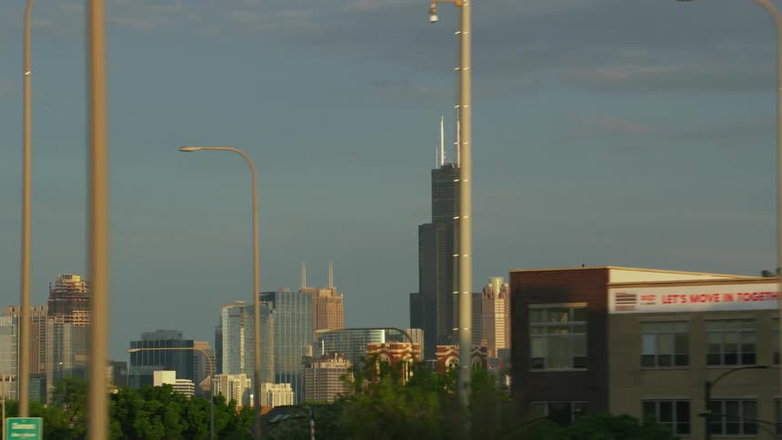A shot of a chicago skyscraper from a vehicle driving on a freeway