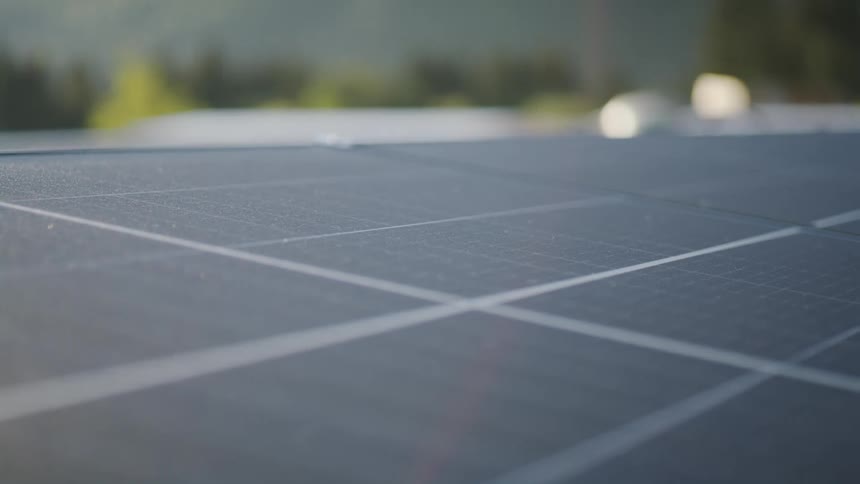 Close up view of solar panels and there are trees in the distance