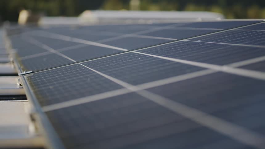 Rectangular solar panels sit in angled rows