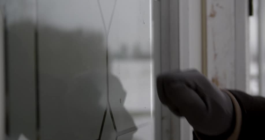 A hand knocks on a white door