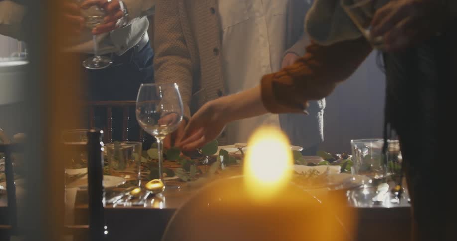 A group of people set a dining room table before a meal