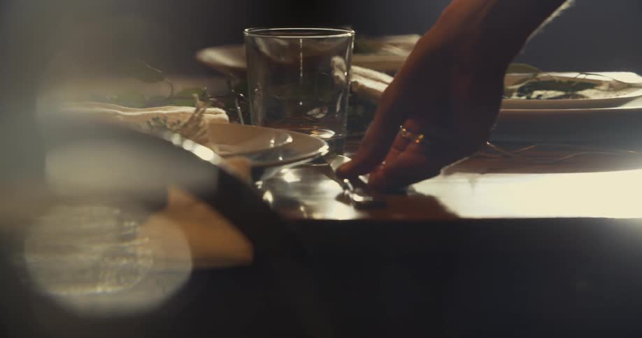 Glass and silverware being set onto a dining table