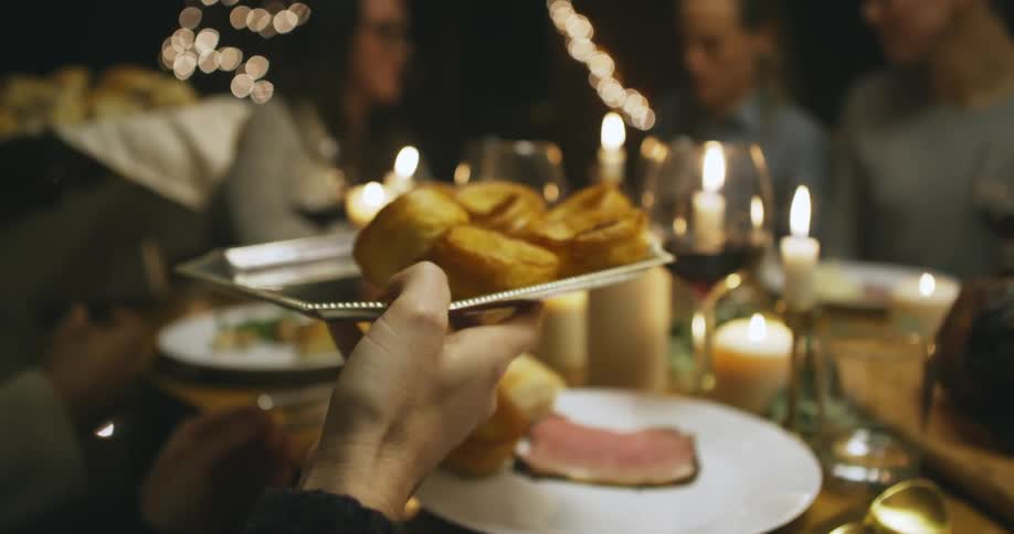 Group of people talking and sharing food at a dinner table
