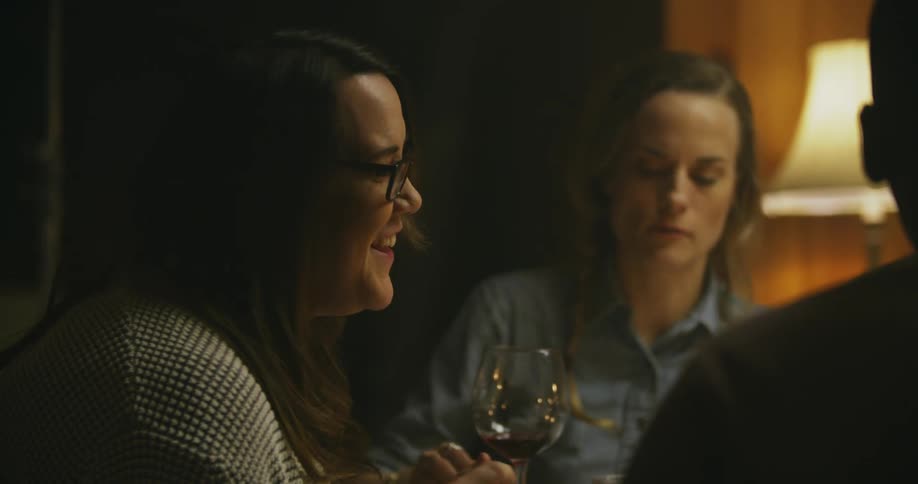 Women laugh and talk at a table
