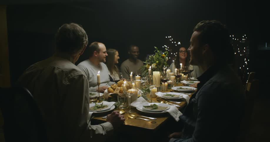 Group of people sitting and talking at a dinner table