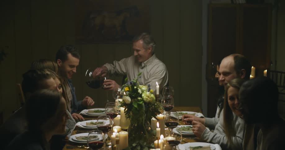 A group of people share wine at a dinner table
