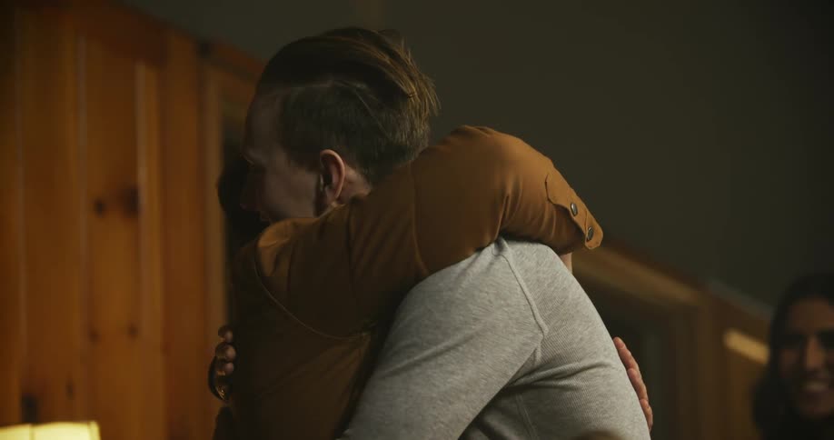 Two men hug as others watch on smiling