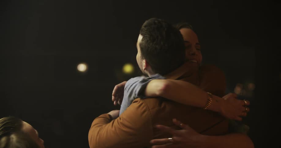 Two men greet their family at the dinner table