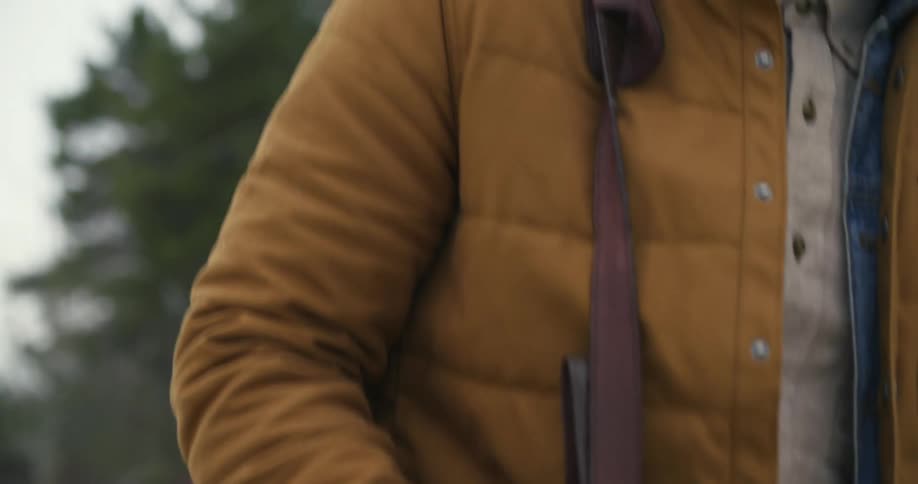 A man carries a messenger bag outside in the cold