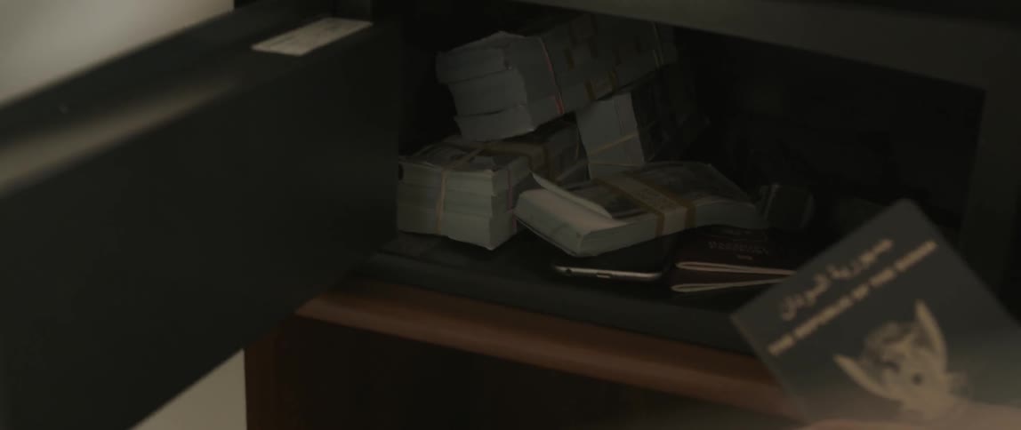 A person opens a safe and pulls out a passport