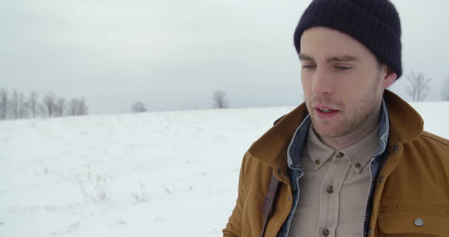 A man walks in a snowy field