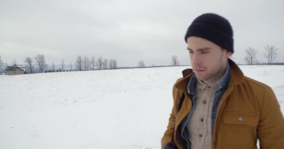 A man walks down a country road in winter
