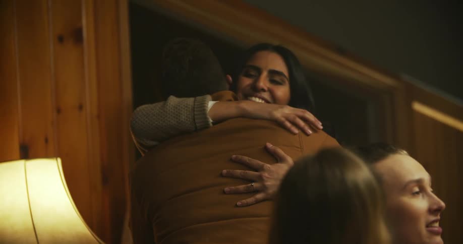 People are talking and hugging in a room