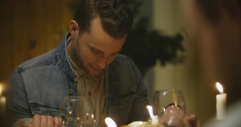 A man bowing his head in prayer at the dinner table